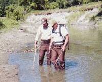 Fisheries staff wading through stream using an back electroshocker to locate larval lamrpey.